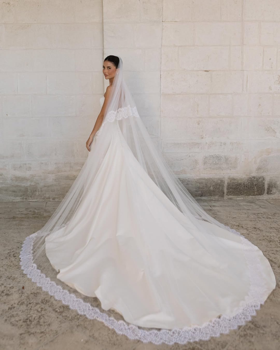 La robe finale et son voile de dentelle, portés par la mariée